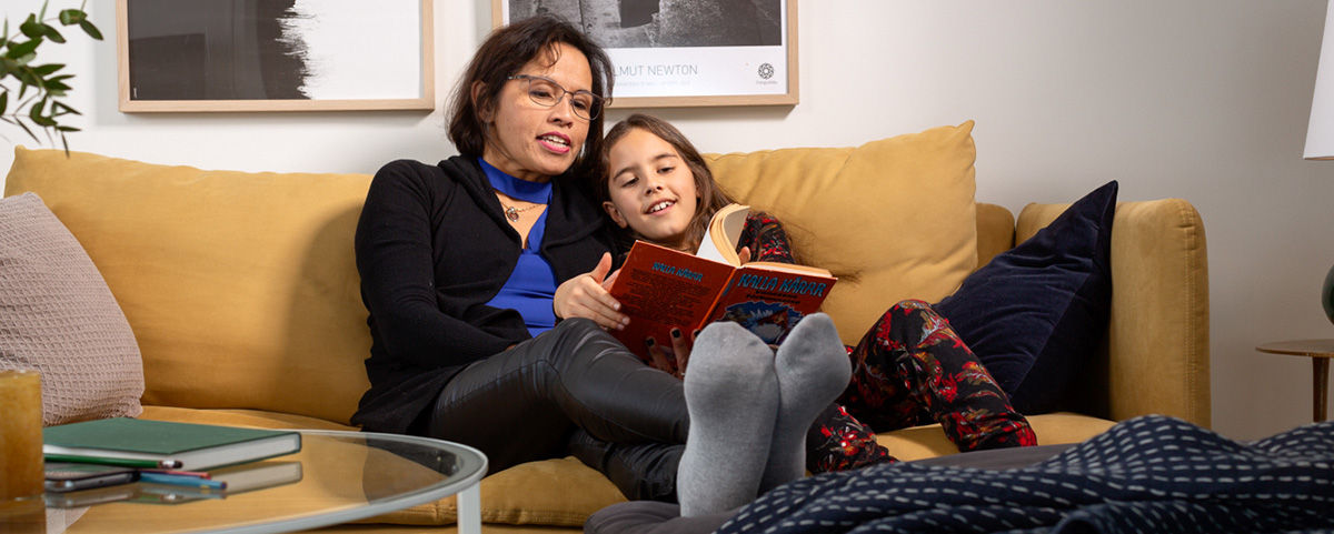 Familj läser bok i soffan
